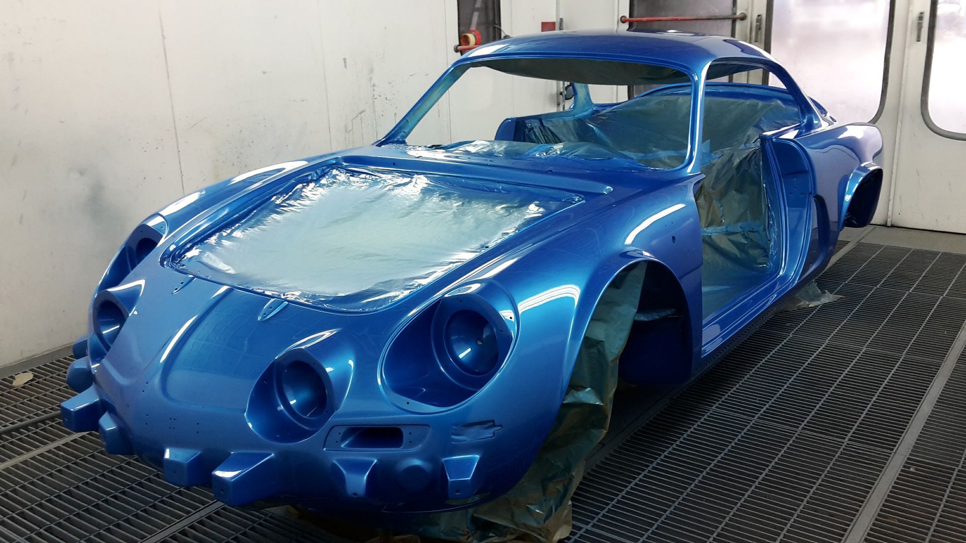 Voiture de sport en cabine de peinture