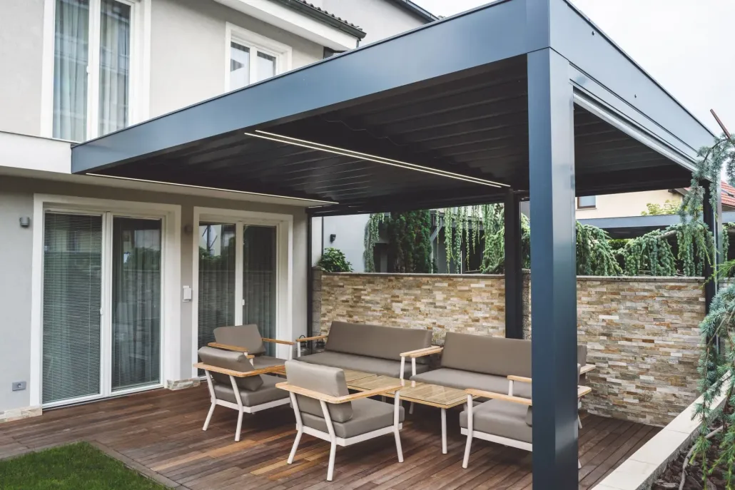 Pergola en aluminium qui abrite un salon de jardin sur une terrasse en bois