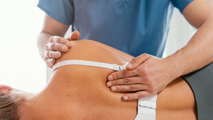 Un hombre le está dando un masaje a una mujer en la espalda.