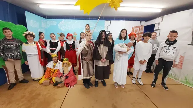 Un grupo de niños vestidos con disfraces posan para una fotografía en una habitación.