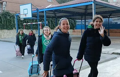 Un grupo de chicas camina por la calle con su equipaje.