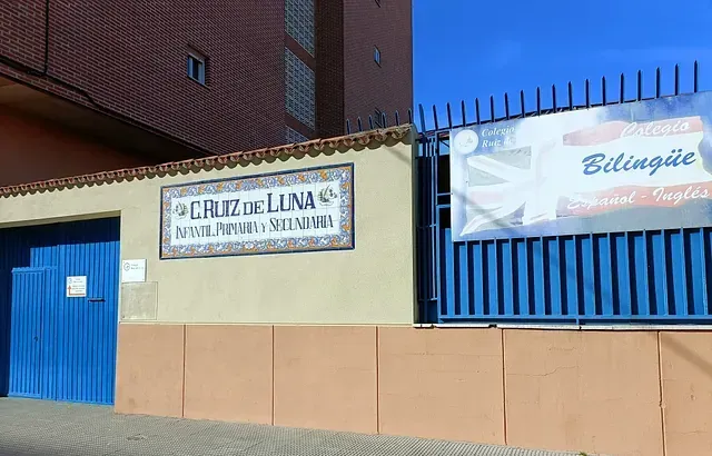 Un edificio con una puerta azul y un cartel en él.
