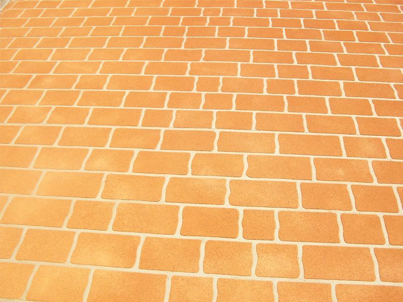 Béton imprimé au pochoir avec motifs de briques orange