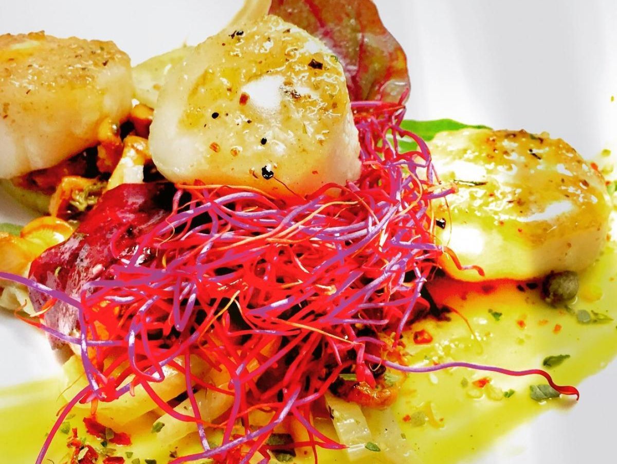 Eine Nahaufnahme eines Tellers mit Nudeln und Fleisch auf einem Tisch.