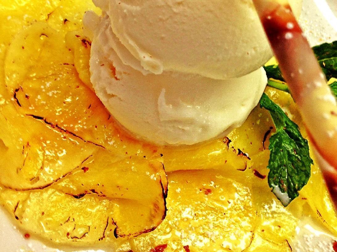 Eine Nahaufnahme eines Tellers mit Essen und Eiscreme obendrauf.