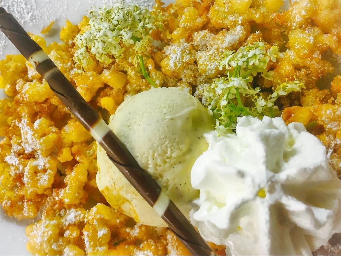 Eine Nahaufnahme von einem Teller mit Essen mit Eis und Schlagsahne