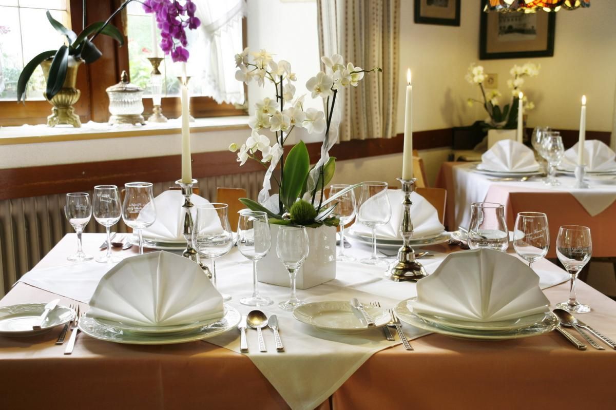 Ein für eine Mahlzeit gedeckter Tisch mit Tellern, Kerzen und Servietten