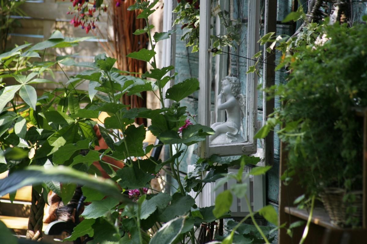 Eine Statue einer Frau ist von Pflanzen in einem Garten umgeben