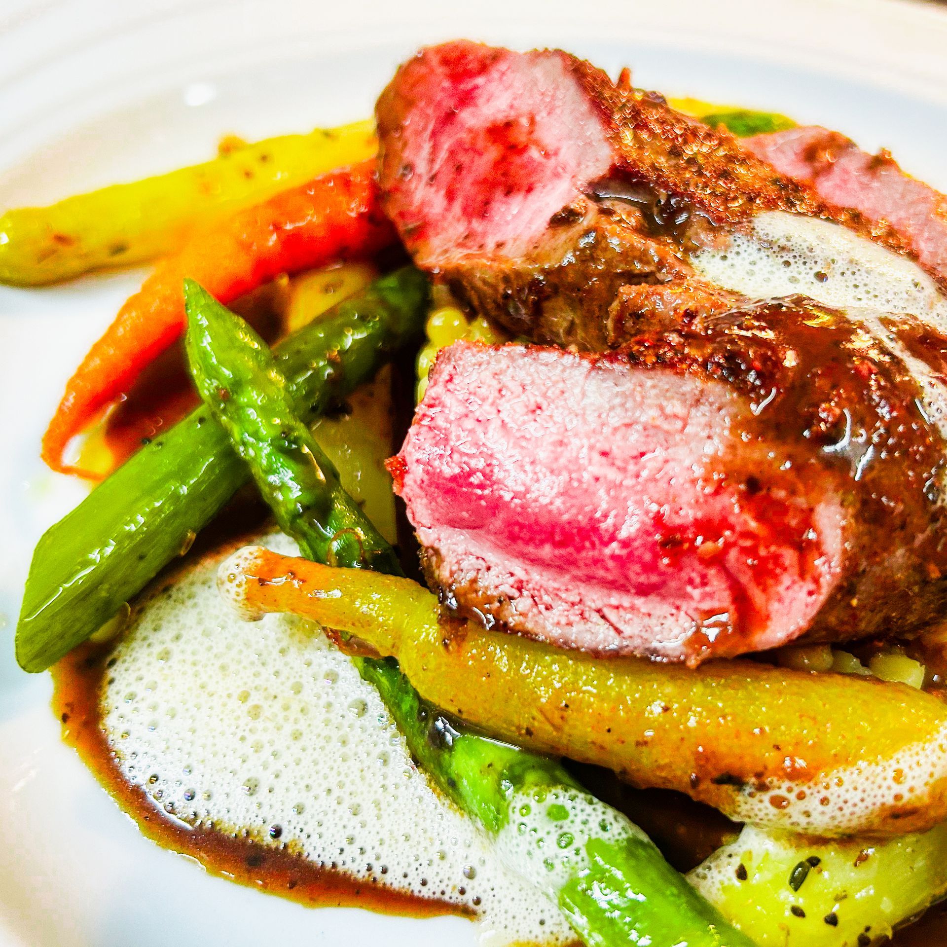 Eine Nahaufnahme eines Tellers mit Fleisch und Gemüse auf einem Tisch.