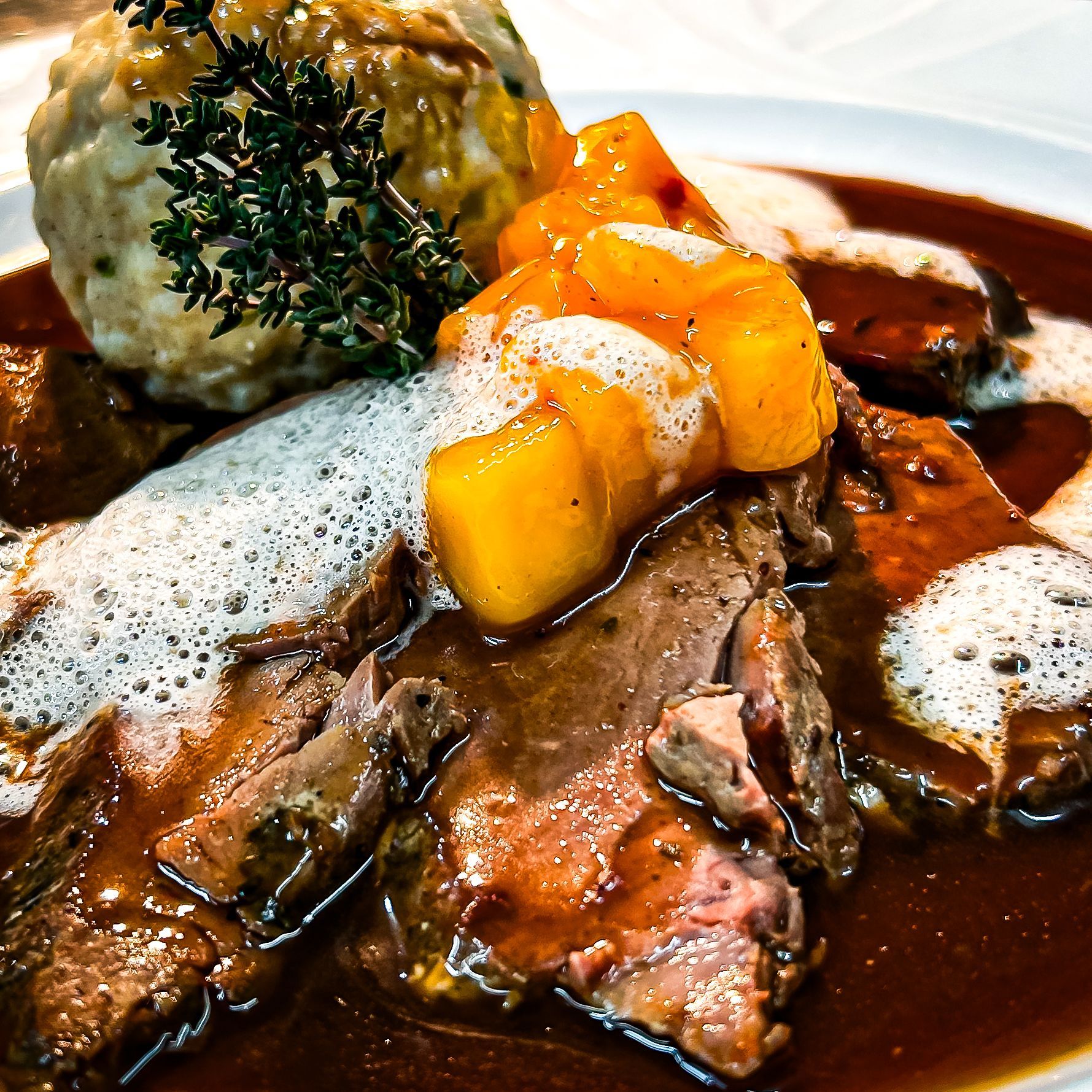 Eine Nahaufnahme von einem Teller mit Essen mit Fleisch und Soße