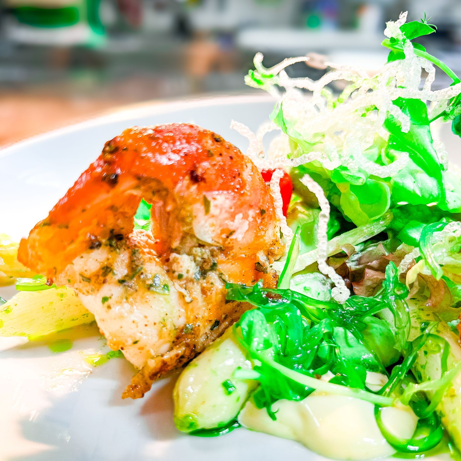 Gegrillte Garnelen und Salat auf einem weißen Teller.