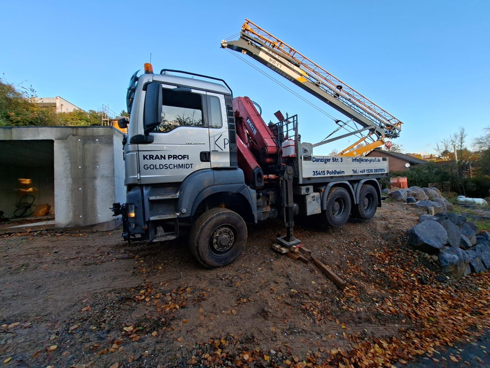 Kran-Profi Goldschmidt - Arbeiter in Schutzkleidung bedient einen Mini-Baukran
