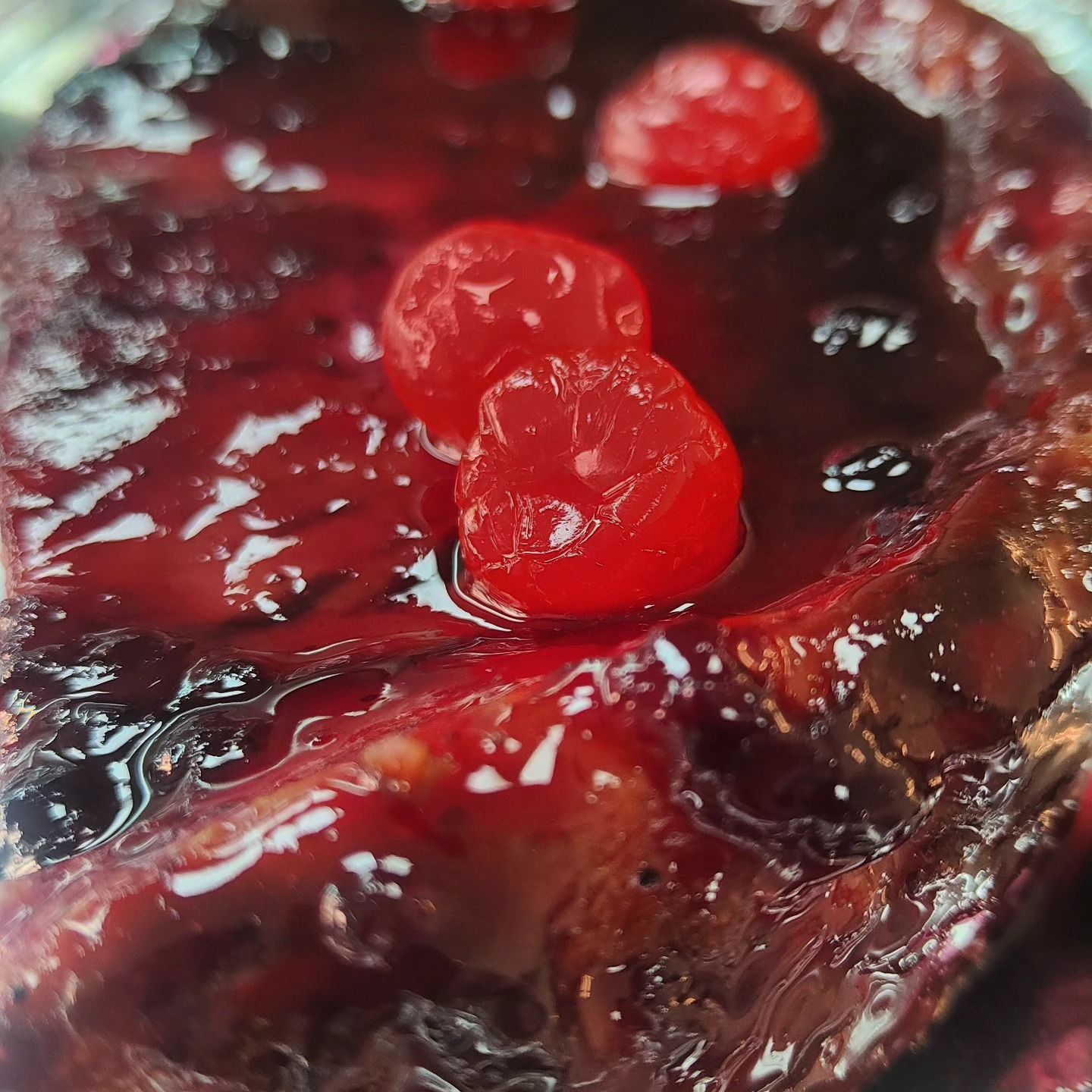 Un primer plano de una salsa de bayas con cerezas.