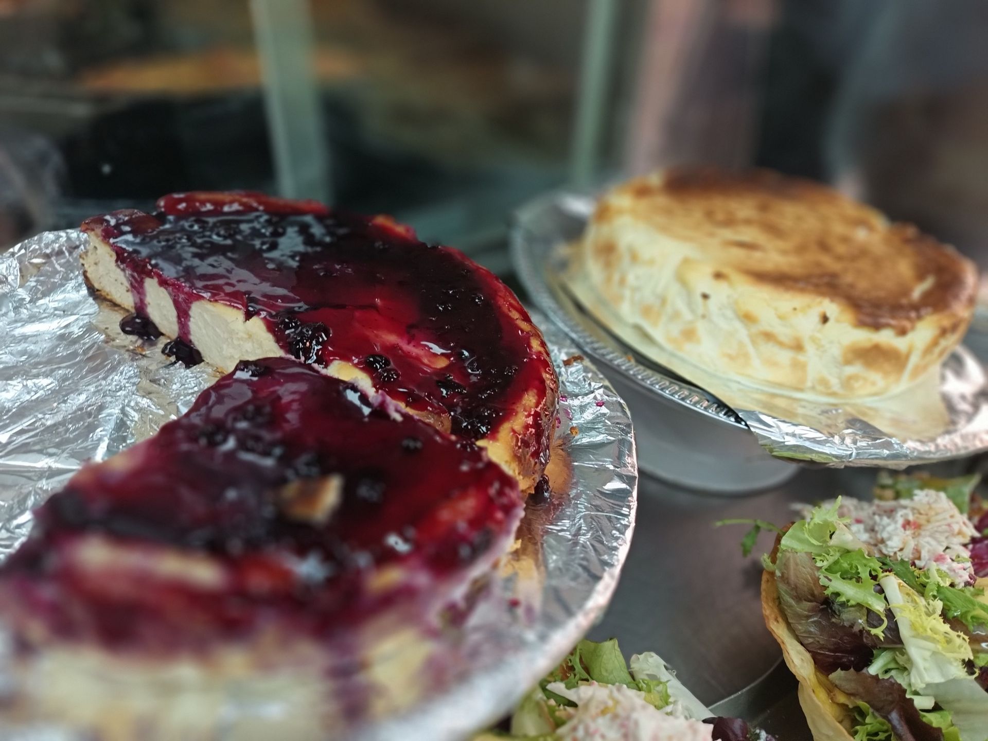 Un primer plano de una tarta de queso y una ensalada en una mesa.