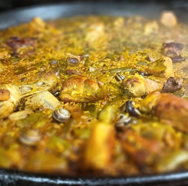 Un primer plano de una sartén llena de arroz, carne y verduras.