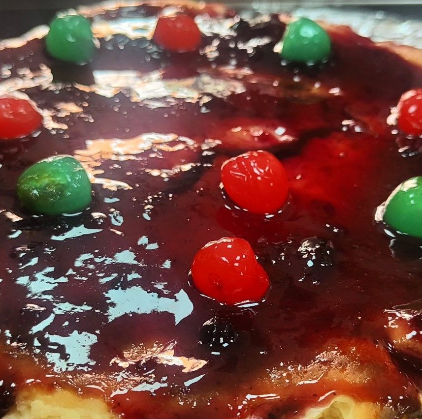 Un primer plano de una pizza con cerezas encima.