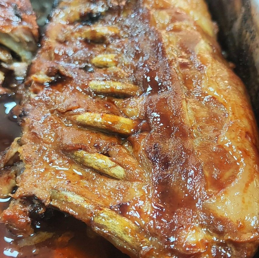 Un primer plano de un trozo de carne con salsa encima.