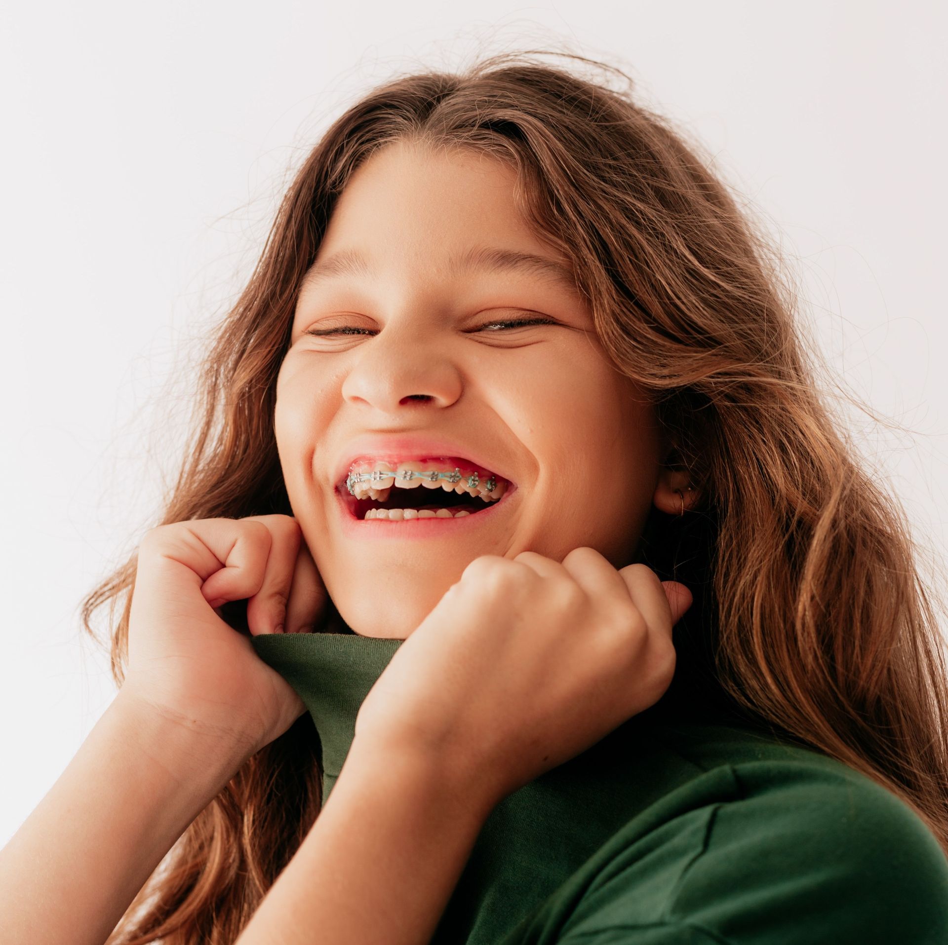 Una niña con aparatos dentales se ríe