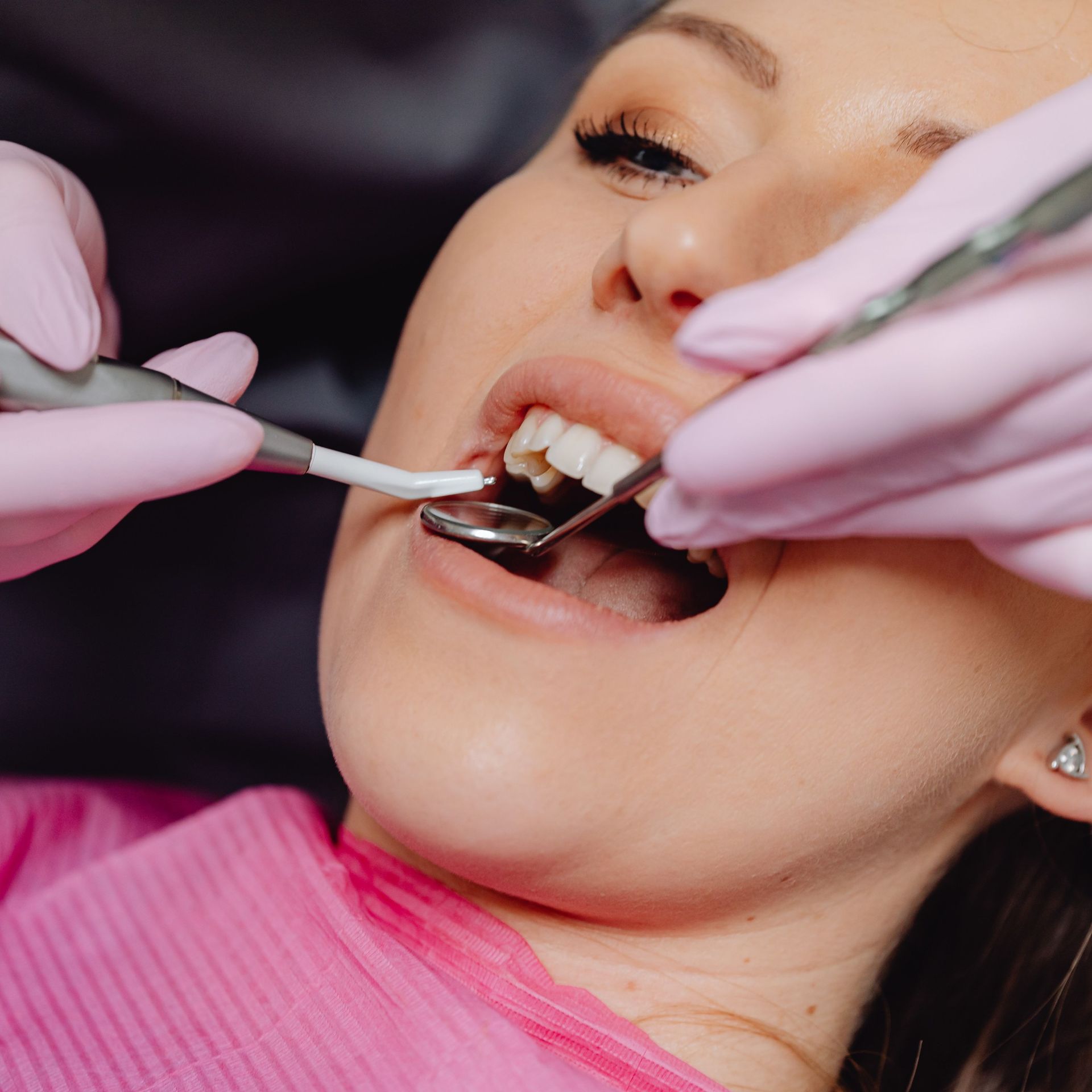 Una mujer está siendo examinada por un dentista.