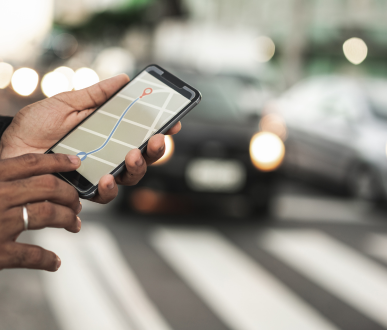 Les mains d'une personne tenant un téléphone affichant une application de navigation.