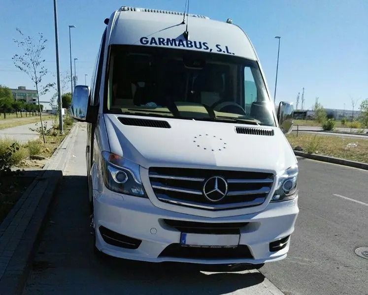Una camioneta Mercedes blanca está estacionada al costado de la carretera.