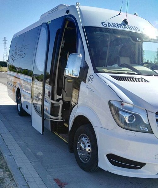Un autobús Garmin blanco está estacionado al costado de la carretera.