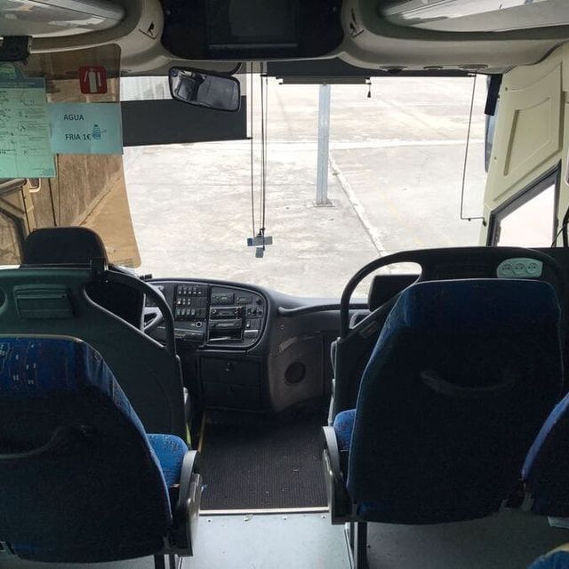 El interior de un autobús con asientos azules.