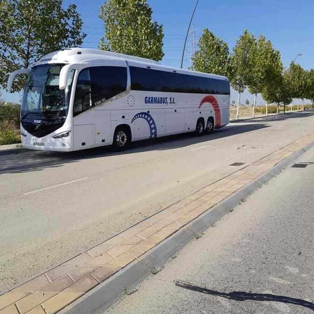 Un autobús blanco con la palabra garajes en el lateral.