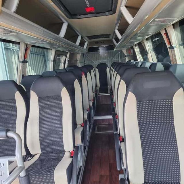 El interior de un autobús con asientos blancos y negros.
