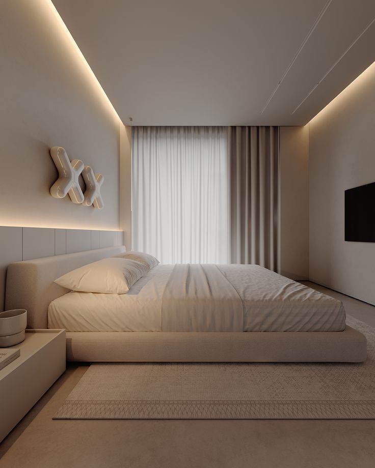 Dormitorio moderno en color beige con cama, mesita de noche y TV montada en la pared.