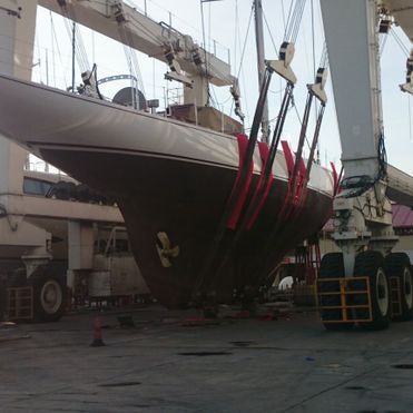 Un gran barco está siendo levantado por una gran grúa