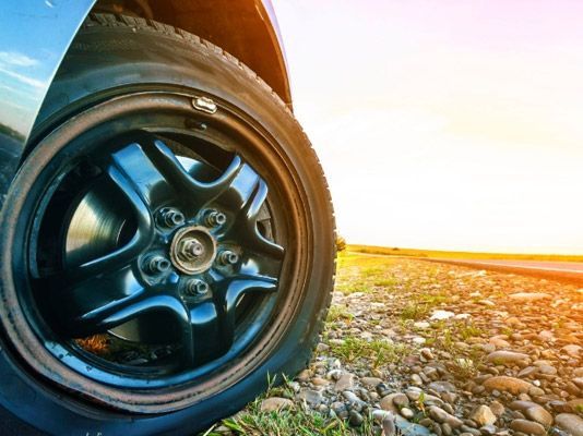 Un primer plano de un neumático de automóvil en un camino de grava.