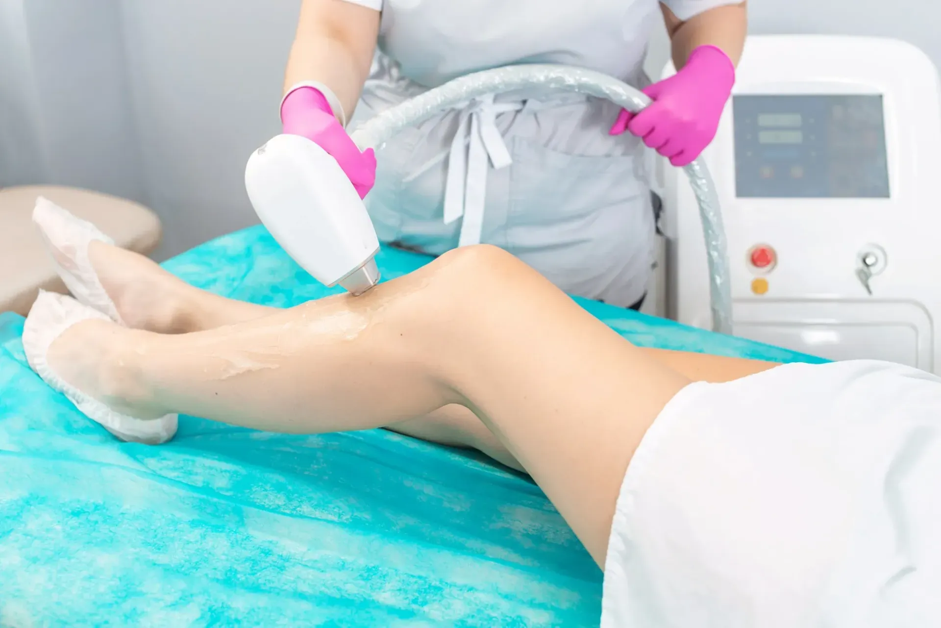 Una persona que recibe depilación láser en la pierna en un entorno médico.