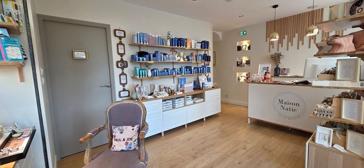 Intérieur lumineux de la boutique avec des étagères de produits, un comptoir et une petite poussette au premier plan.