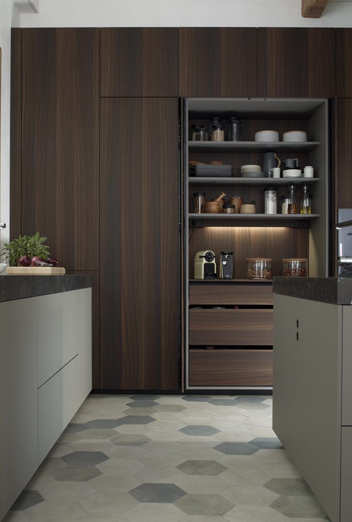 Mueble de despensa de madera oscura abierto, que revela estantes con alimentos y cajones en una cocina moderna