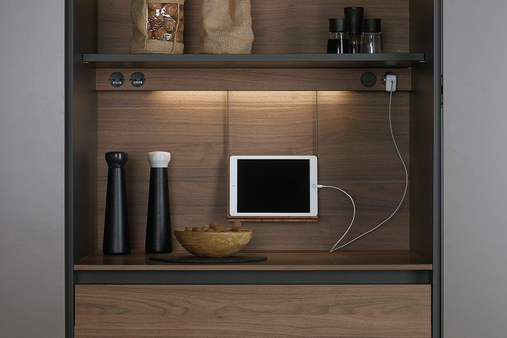 Mueble de cocina de madera con tablet incorporada, estante con especias e iluminación bajo el estante.