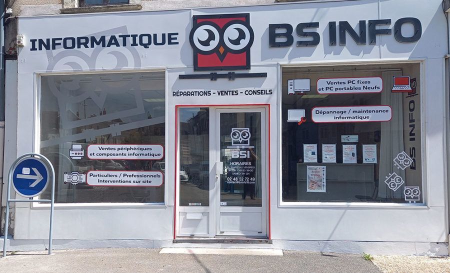 Magasin BS INFO avec porte vitrée, enseignes de réparation informatique et vitrines sombres