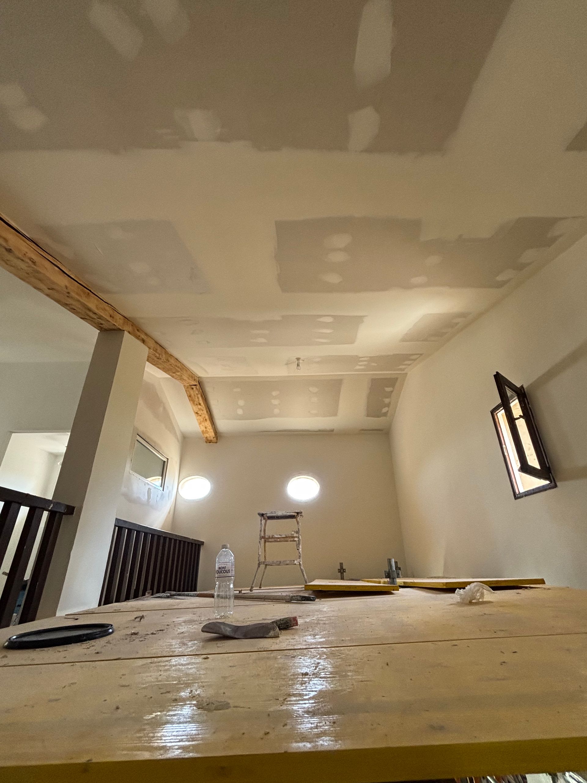 Pièce en rénovation avec plafond en plaques de plâtre recouvertes d'enduit.