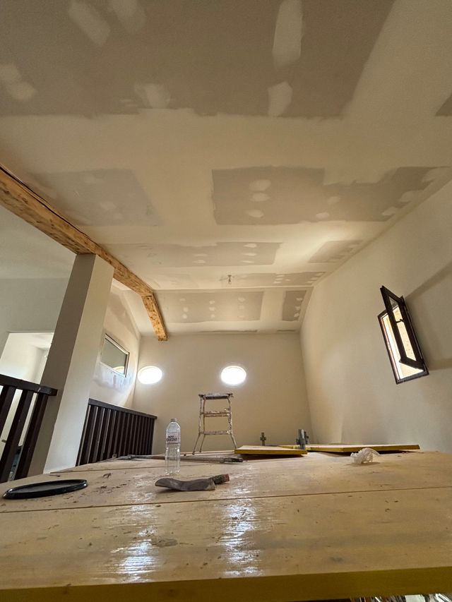 Pièce en rénovation avec plafond en plaques de plâtre recouvertes d'enduit.