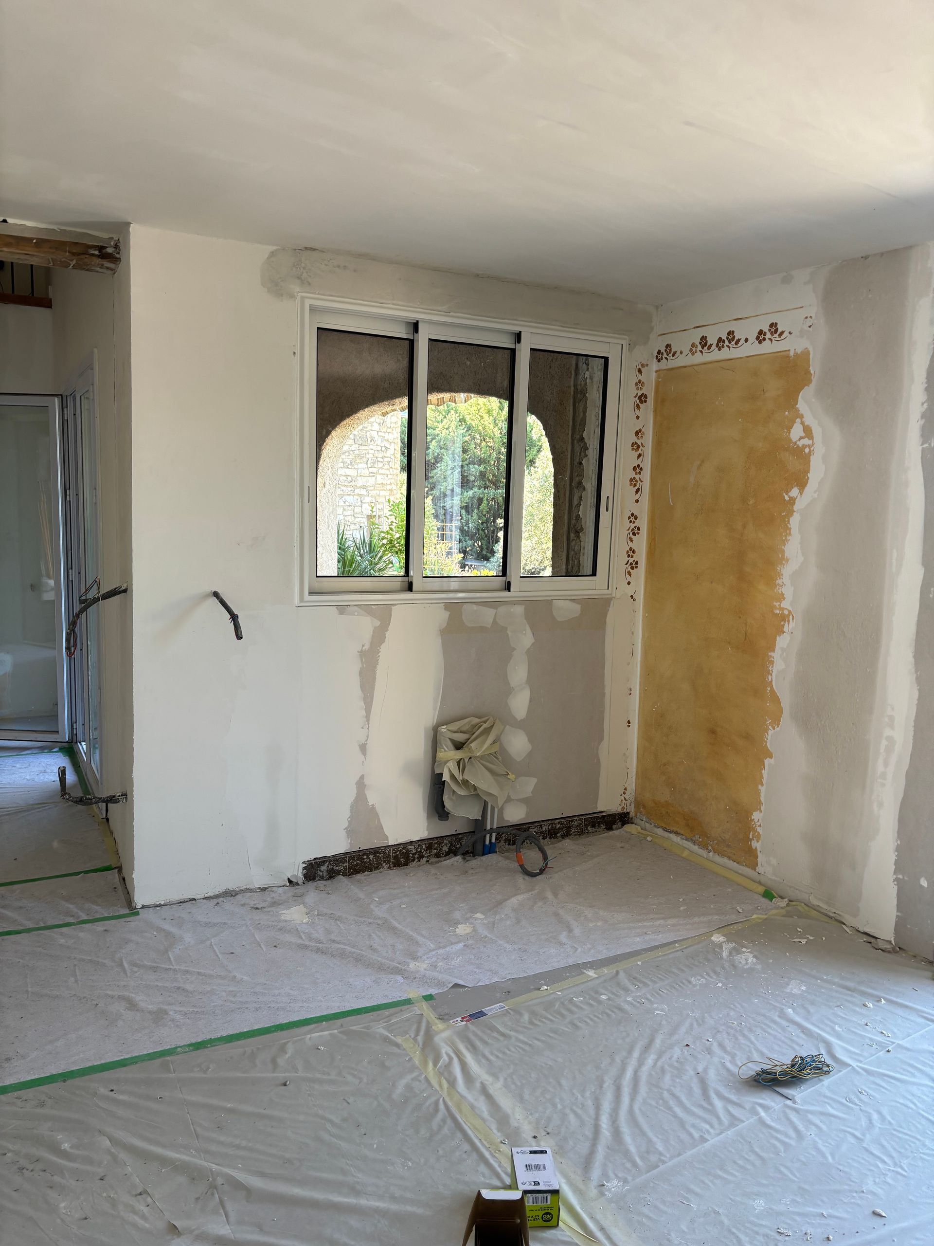 Travaux de plâtrerie en cours dans une pièce.