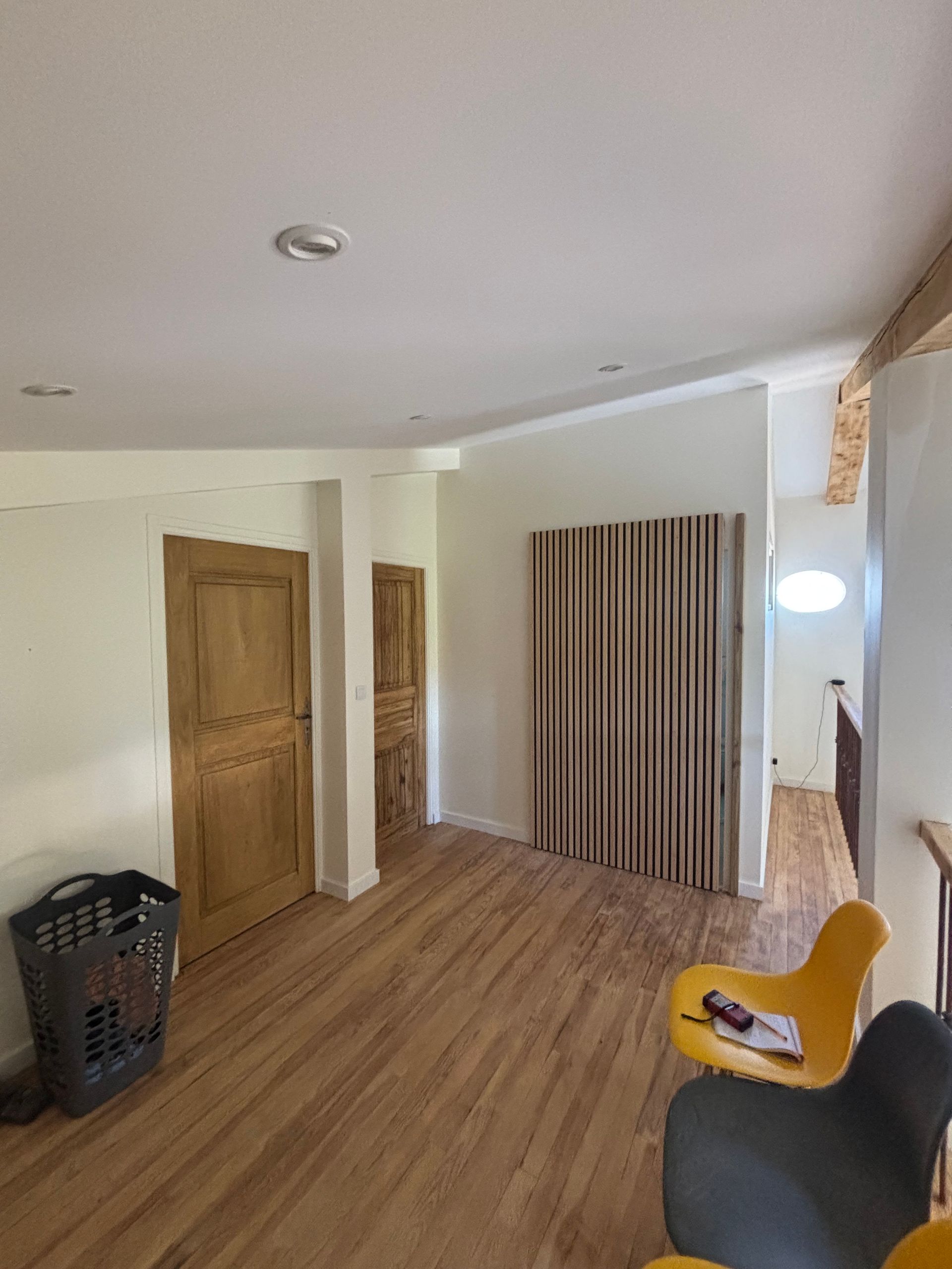 Une pièce rénovée avec un sol en parquet.