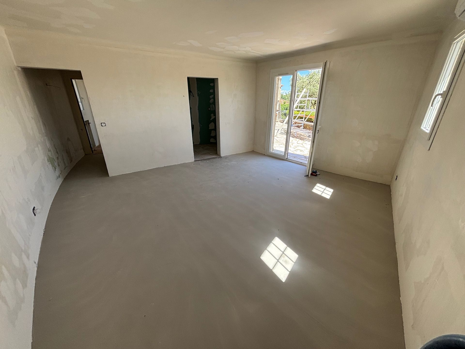 Une pièce en rénovation avec un ragréage du sol.