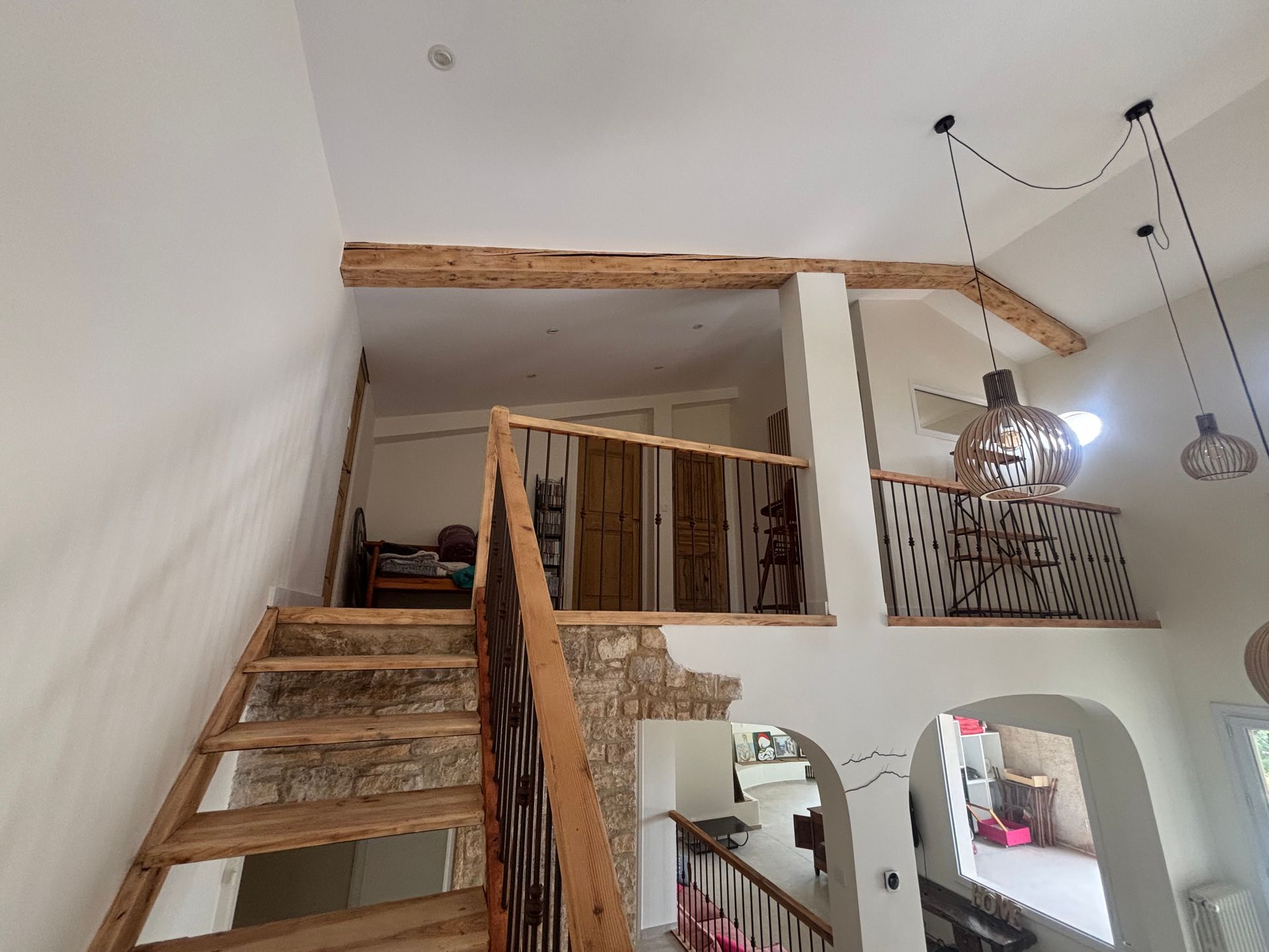 Intérieur rénové avec un escalier en bois menant à un étage.