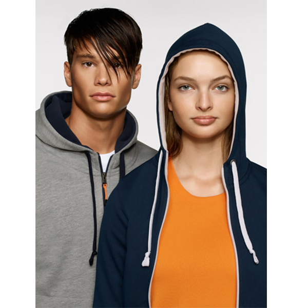 Mann und Frau in Kapuzenpullovern, marineblau und grau, schauen in die Kamera.