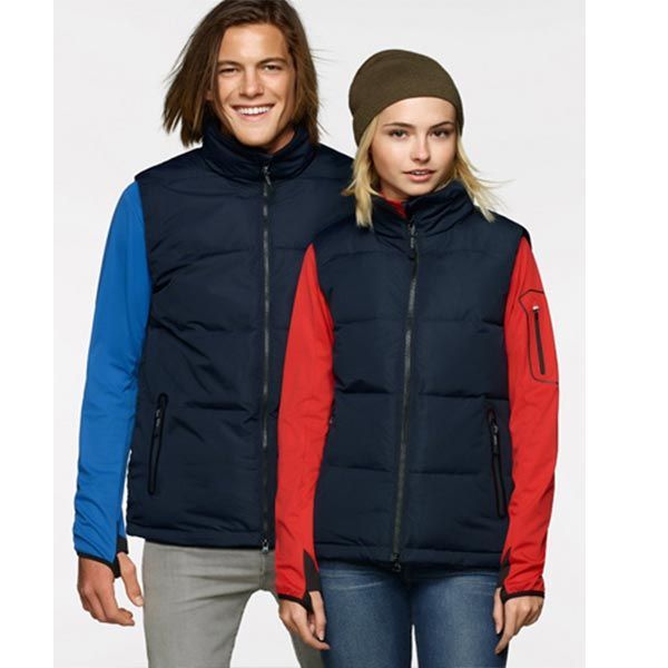 Mann und Frau in marineblauen Westen mit Reißverschluss über langärmeligen Hemden stehen zusammen.