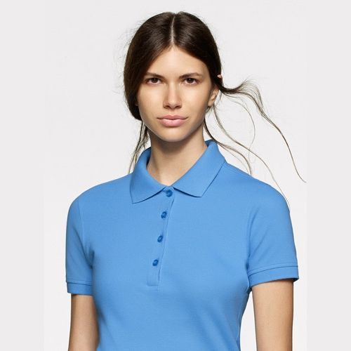 Frau in hellblauem Poloshirt, blickt in die Kamera.