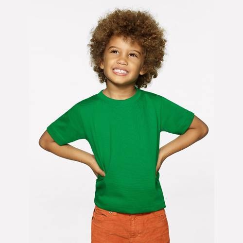 Junge in grünem T-Shirt und orangefarbenen Shorts lächelt, Hände in die Hüften gestemmt.