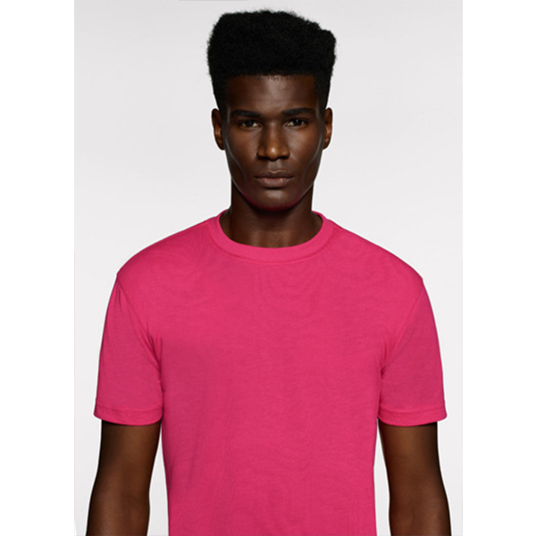 Mann in leuchtend rosa T-Shirt, vor weißem Hintergrund stehend.