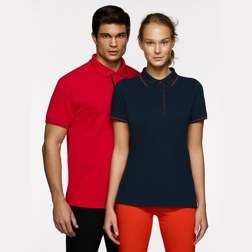 Mann im roten Poloshirt und Frau im marineblauen Poloshirt, beide mit orangefarbenen Akzenten, posieren.