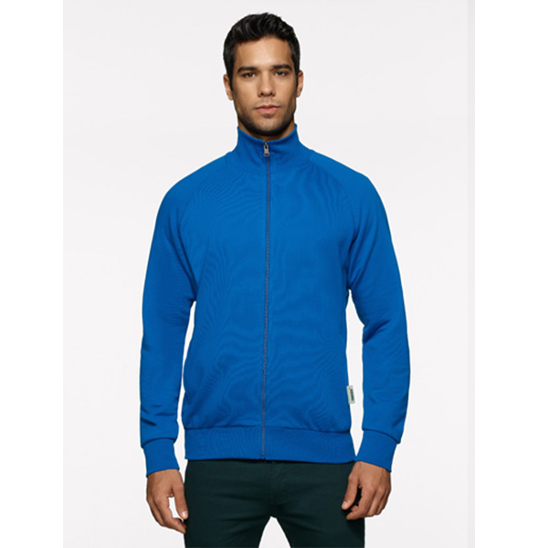 Mann in einer blauen Jacke mit Reißverschluss. Er trägt dunkelgrüne Hosen vor einem weißen Hintergrund.